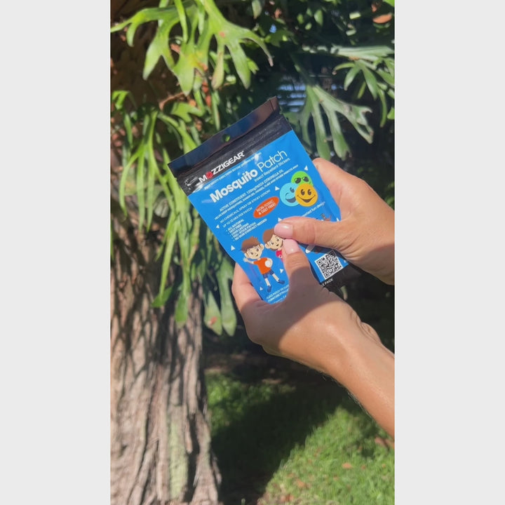 Video of a mother with her kids holding and showing Mozzigear Mosquito Patch Stickers, explaining their natural, DEET-free formulation and fun designs for kids. Demonstrates how the adhesive patches can be applied to clothes, strollers, or furniture to repel mosquitoes and insects for up to 12 hours